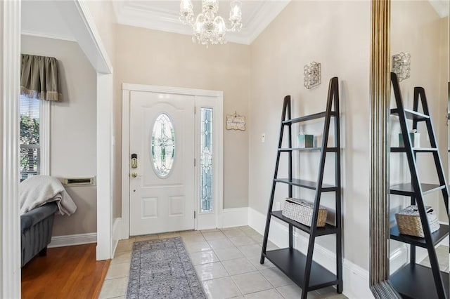 foyer with light hardwood / wood-style flooring, a chandelier, and ornamental molding