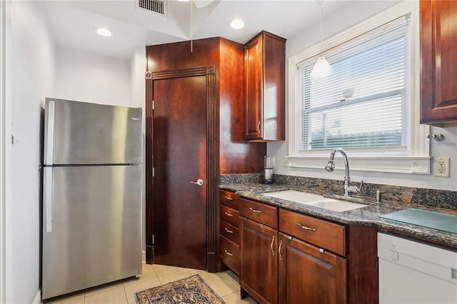 kitchen featuring stainless steel fridge, sink, light tile patterned floors, decorative light fixtures, and dishwasher