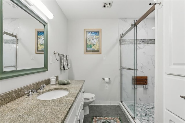 bathroom featuring tile patterned flooring, vanity, toilet, and an enclosed shower