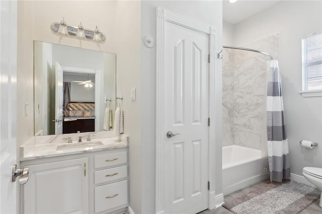 full bathroom with ceiling fan, vanity, shower / tub combo, and toilet