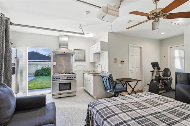 bedroom with stainless steel fridge, ceiling fan, sink, and light colored carpet