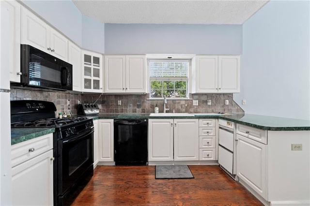 kitchen with sink, white cabinetry, dark wood-type flooring, and black appliances