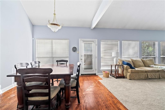 dining space featuring beamed ceiling and hardwood / wood-style flooring