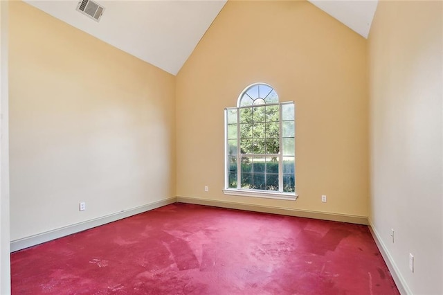 carpeted empty room featuring high vaulted ceiling