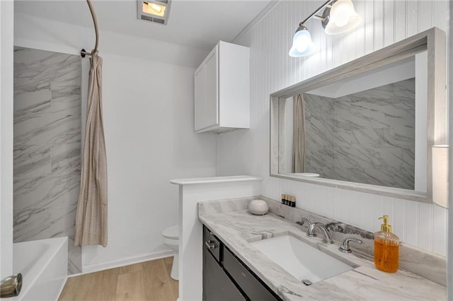 full bathroom with wood-type flooring, vanity, toilet, and tiled shower / bath