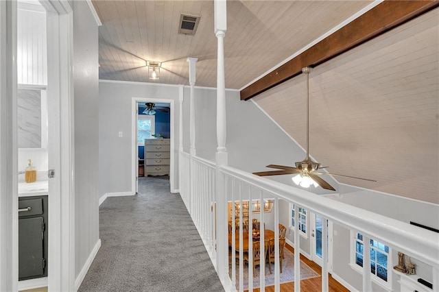 hallway featuring lofted ceiling with beams, carpet floors, ornamental molding, and wooden ceiling