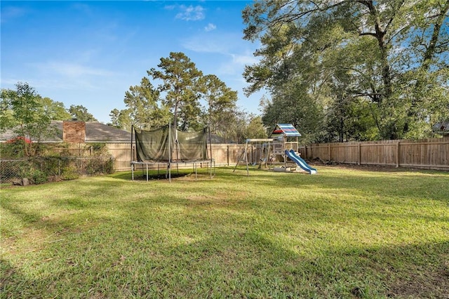 view of yard featuring a playground and a trampoline