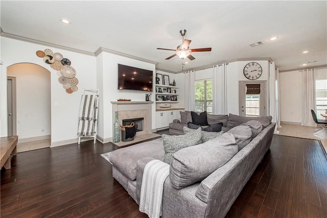 living room featuring crown molding, ceiling fan, and dark wood-type flooring