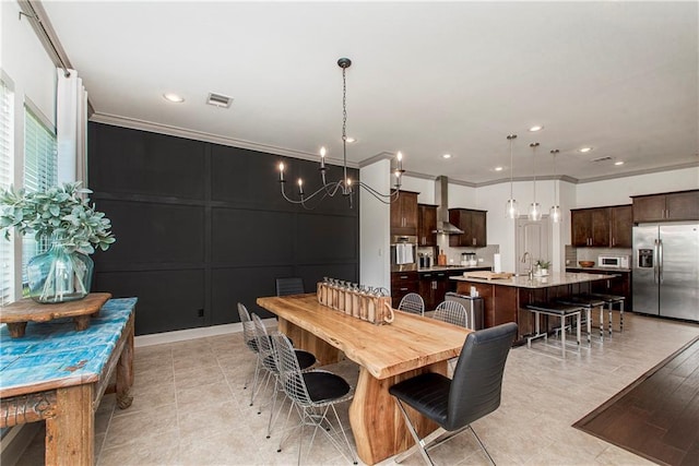 dining room featuring sink, crown molding, and an inviting chandelier