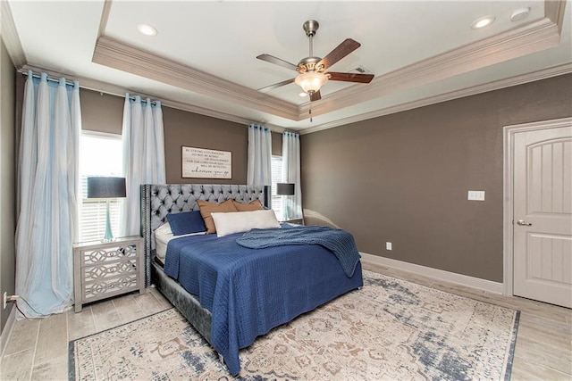 bedroom featuring a raised ceiling, ceiling fan, light hardwood / wood-style flooring, and ornamental molding