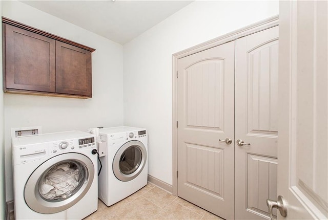 laundry room with separate washer and dryer, light tile patterned floors, and cabinets