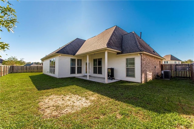 back of house with central AC, a patio area, and a yard