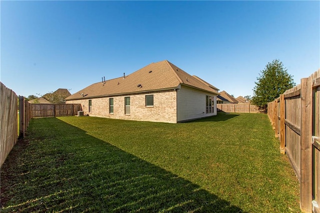 back of property featuring a lawn and central air condition unit