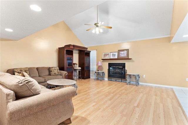 living room with high vaulted ceiling, a fireplace, wood finished floors, a ceiling fan, and baseboards