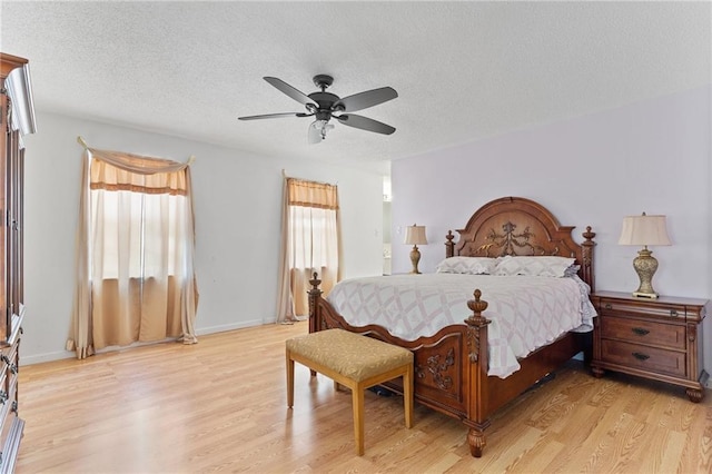 bedroom with light wood-style floors, baseboards, a ceiling fan, and a textured ceiling