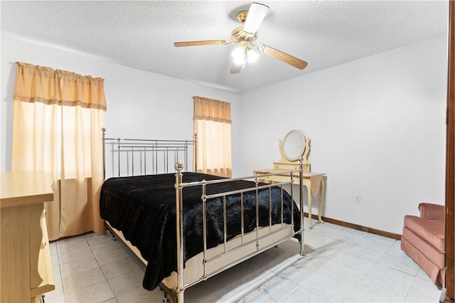 bedroom featuring a textured ceiling, multiple windows, a ceiling fan, and baseboards