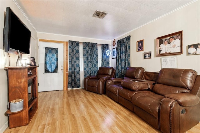 living room featuring a textured ceiling, light hardwood / wood-style floors, and crown molding