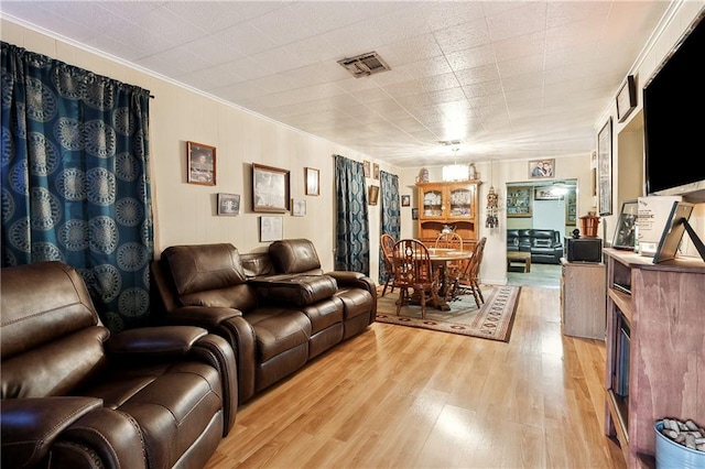 living room with light hardwood / wood-style floors and ornamental molding