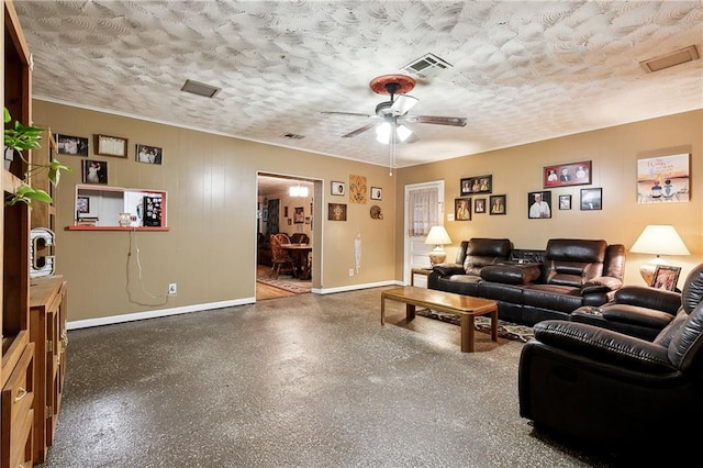 living room featuring ceiling fan and a textured ceiling