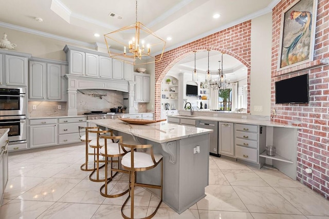 kitchen with a breakfast bar area, a kitchen island, kitchen peninsula, stainless steel appliances, and brick wall