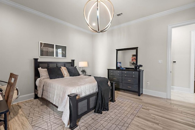 bedroom with light hardwood / wood-style flooring, an inviting chandelier, and ornamental molding