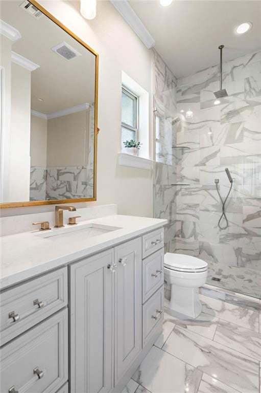 bathroom with tiled shower, toilet, vanity, and ornamental molding