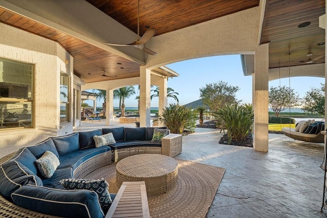 view of patio / terrace with ceiling fan, a water view, and an outdoor hangout area