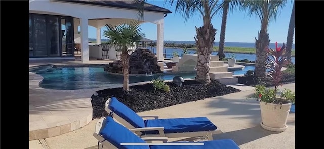 view of swimming pool with a water view and a patio