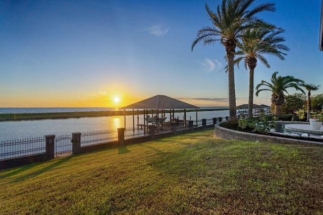 view of dock featuring a gazebo, a yard, and a water view