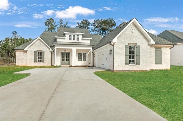 view of front of house featuring a front yard, a porch, and a garage