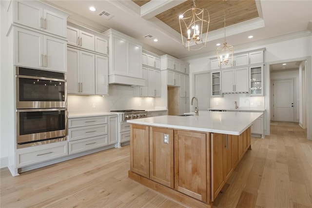 kitchen with glass insert cabinets, light countertops, white cabinets, and a spacious island