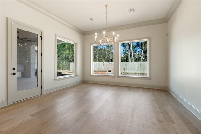 unfurnished dining area with ceiling fan with notable chandelier, light hardwood / wood-style floors, and ornamental molding