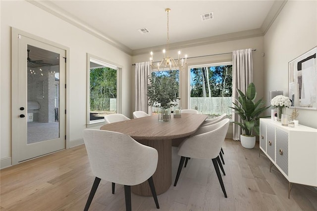 dining area featuring crown molding, light hardwood / wood-style flooring, and ceiling fan with notable chandelier