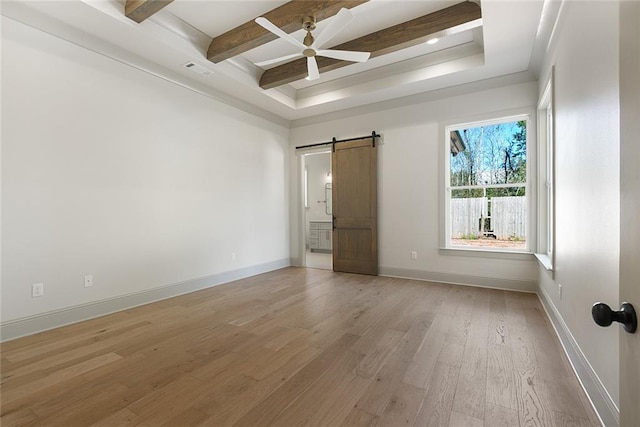 unfurnished room featuring a barn door, baseboards, a ceiling fan, light wood-type flooring, and beam ceiling