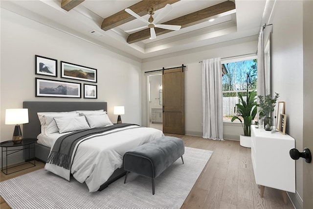 bedroom with ceiling fan, a barn door, visible vents, light wood-style floors, and beam ceiling