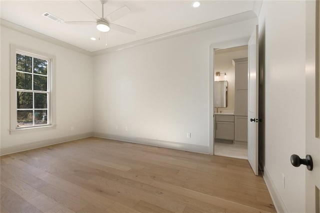 unfurnished room with a ceiling fan, light wood-type flooring, visible vents, and baseboards