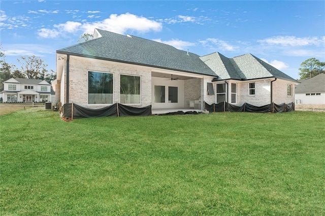 back of property with ceiling fan, a yard, and cooling unit