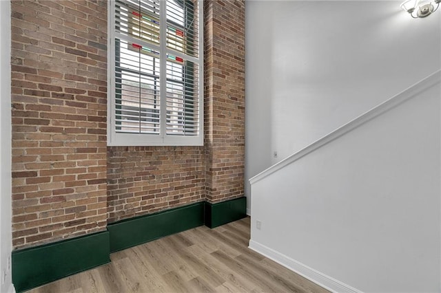 interior space featuring light wood-type flooring and brick wall