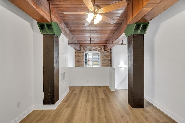 interior space with beam ceiling, ceiling fan, brick wall, light hardwood / wood-style floors, and wood ceiling