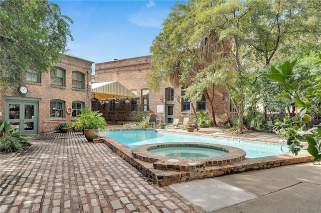 view of swimming pool featuring an in ground hot tub and a patio