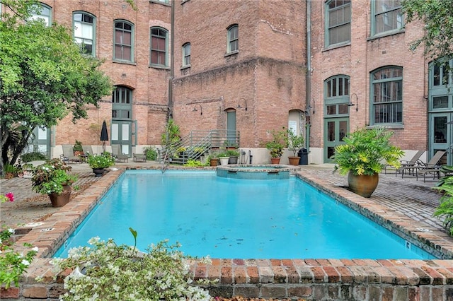 view of pool with a hot tub