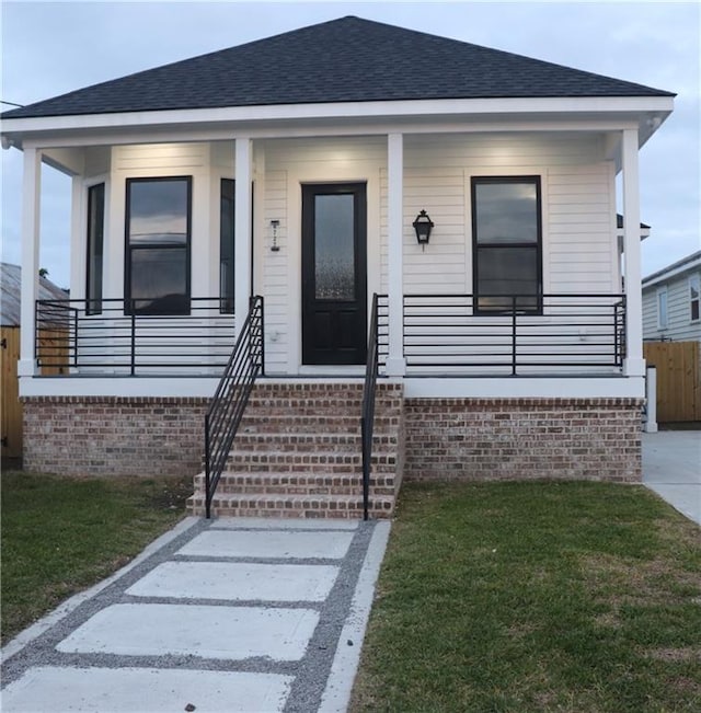 bungalow featuring a porch and a front lawn