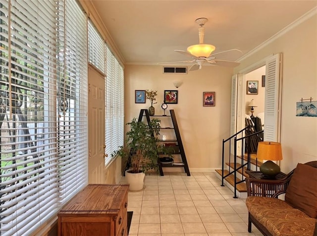 interior space with ornamental molding and ceiling fan