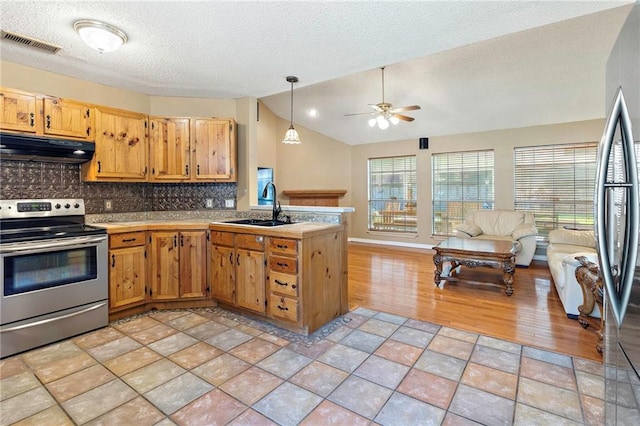 kitchen featuring sink, stainless steel appliances, backsplash, lofted ceiling, and decorative light fixtures