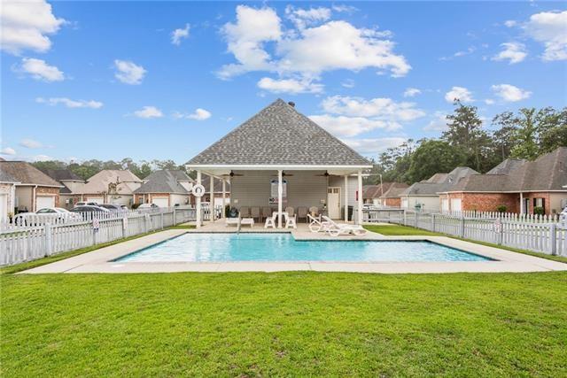 view of swimming pool featuring a lawn, ceiling fan, and a patio
