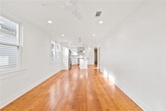 unfurnished living room featuring light hardwood / wood-style floors and ceiling fan