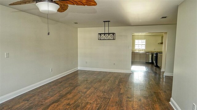 361 Helis Dr, Westwego, LA 70094 - unfurnished room featuring dark wood-style floors, ceiling fan, baseboards, and a sink