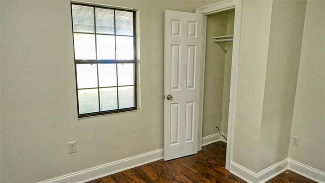 361 Helis Dr, Westwego, LA 70094 - unfurnished bedroom with baseboards, dark wood-style flooring, and a closet