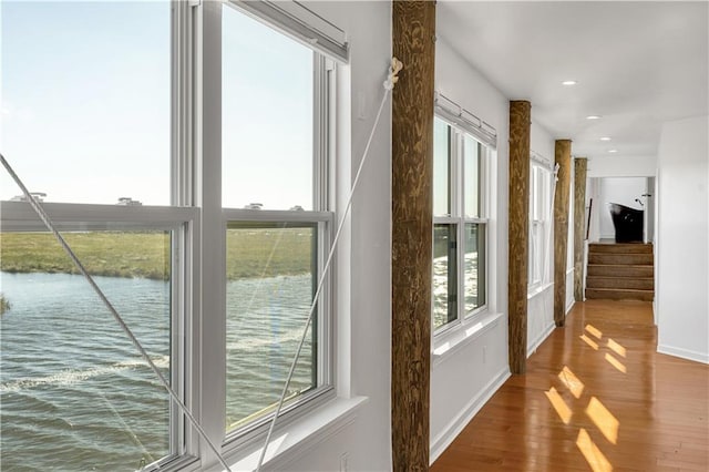 entryway with hardwood / wood-style floors and a water view