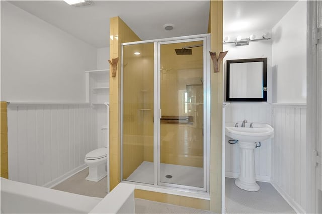 bathroom featuring tile patterned floors, an enclosed shower, and toilet